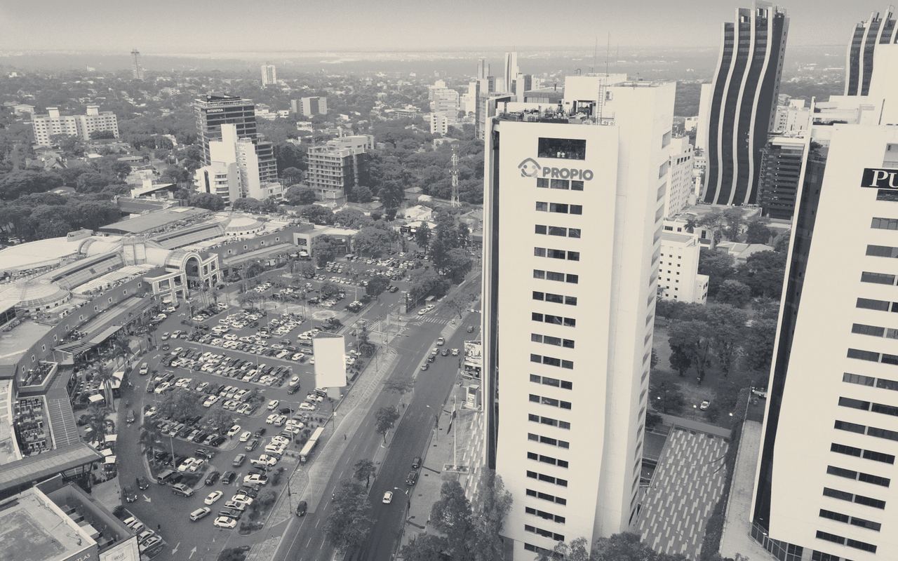 Vista aérea de una avenida con torres de oficinas y tránsito.