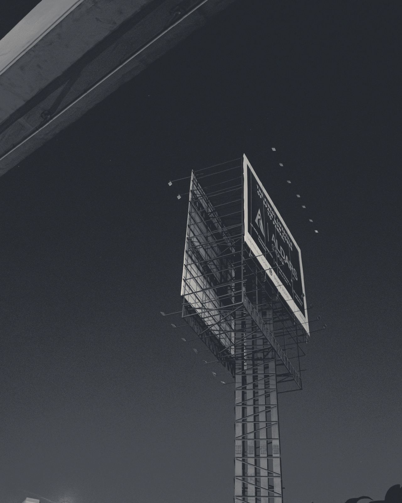 Estructura de cartelería publicitaria contra el cielo al anochecer.
