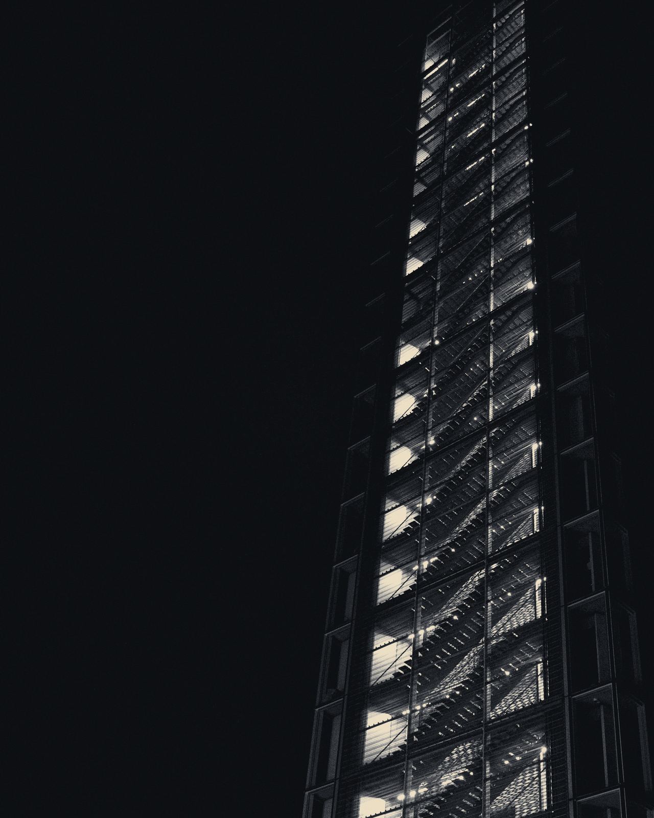 Torre de oficinas de noche, con las plantas iluminadas.